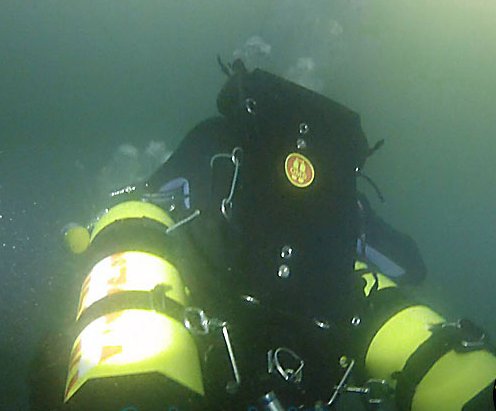 A sidemount diver with cylinders and lights