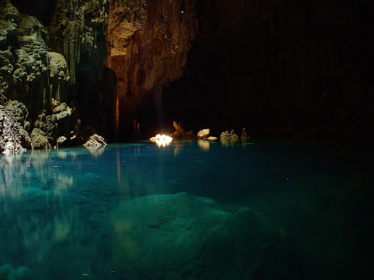Limestone formations on the walls and under the water inside Abismo Anhumas (photo: Lauro Sirgado, 2009, CC BY-SA 3.0).